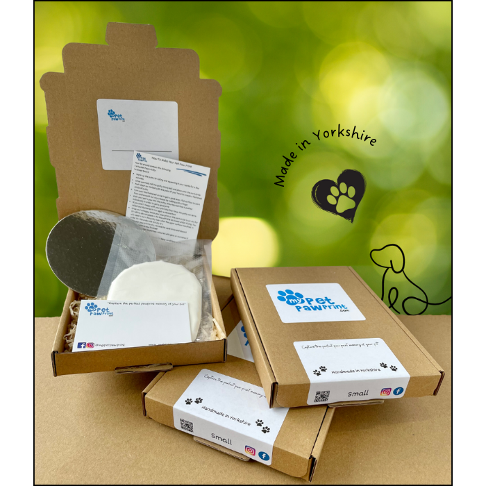 Three paw print kits. One open showing the contents with packet clay and two closed kits